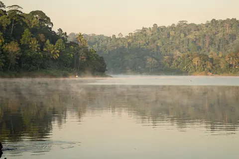AI illustration: Morning mist drifting over the calm water of Sungai Selangor Dam surrounded by green hills near Kuala Kubu Bharu